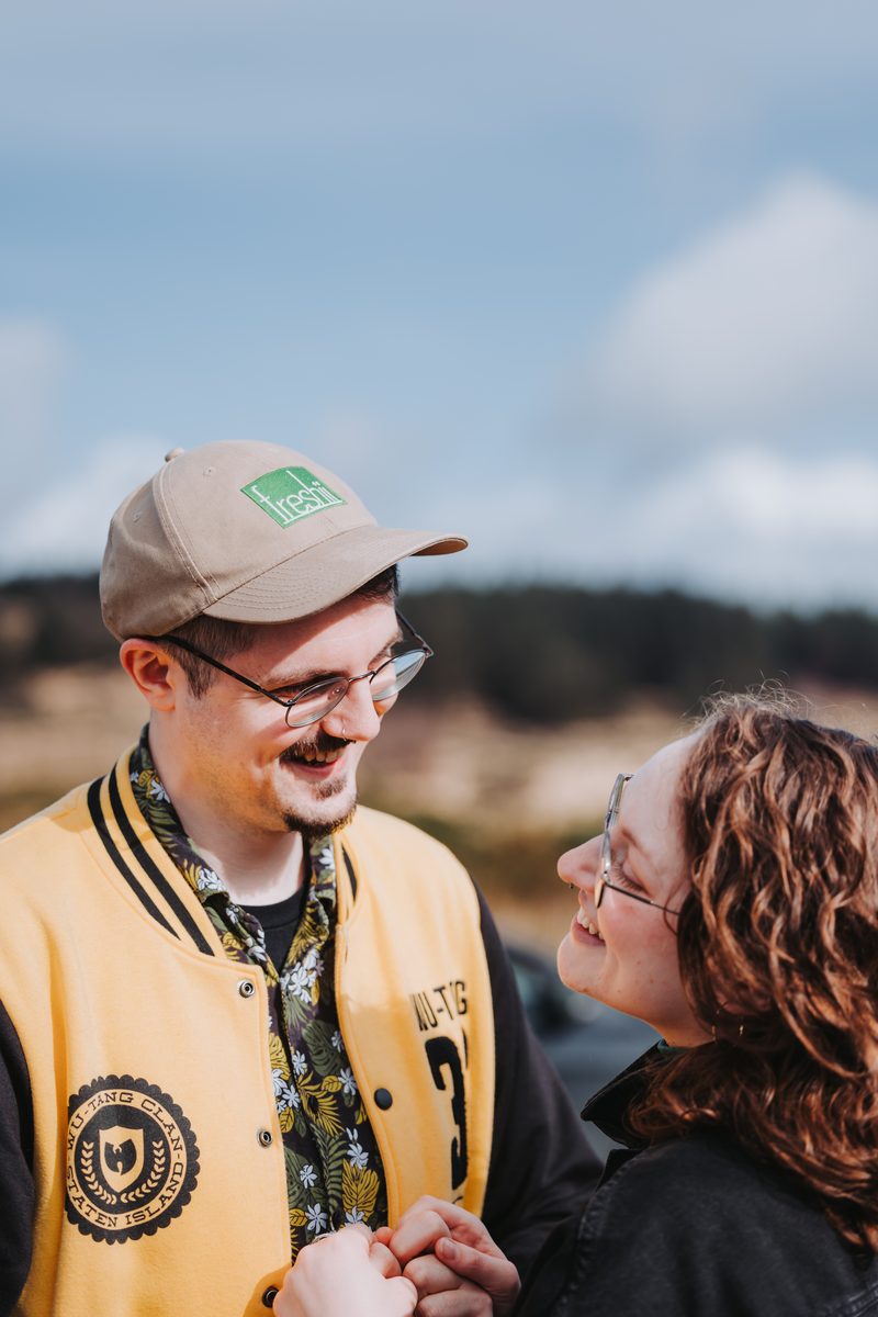 Couple laughing together outdoors on a windy day