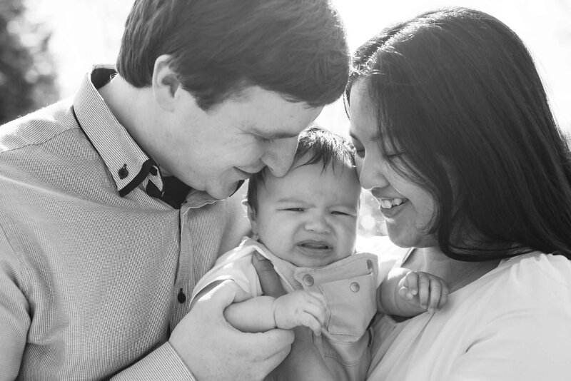 Parents smiling with their baby in black and white