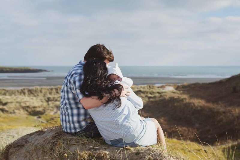 Family embracing while looking out over the coast