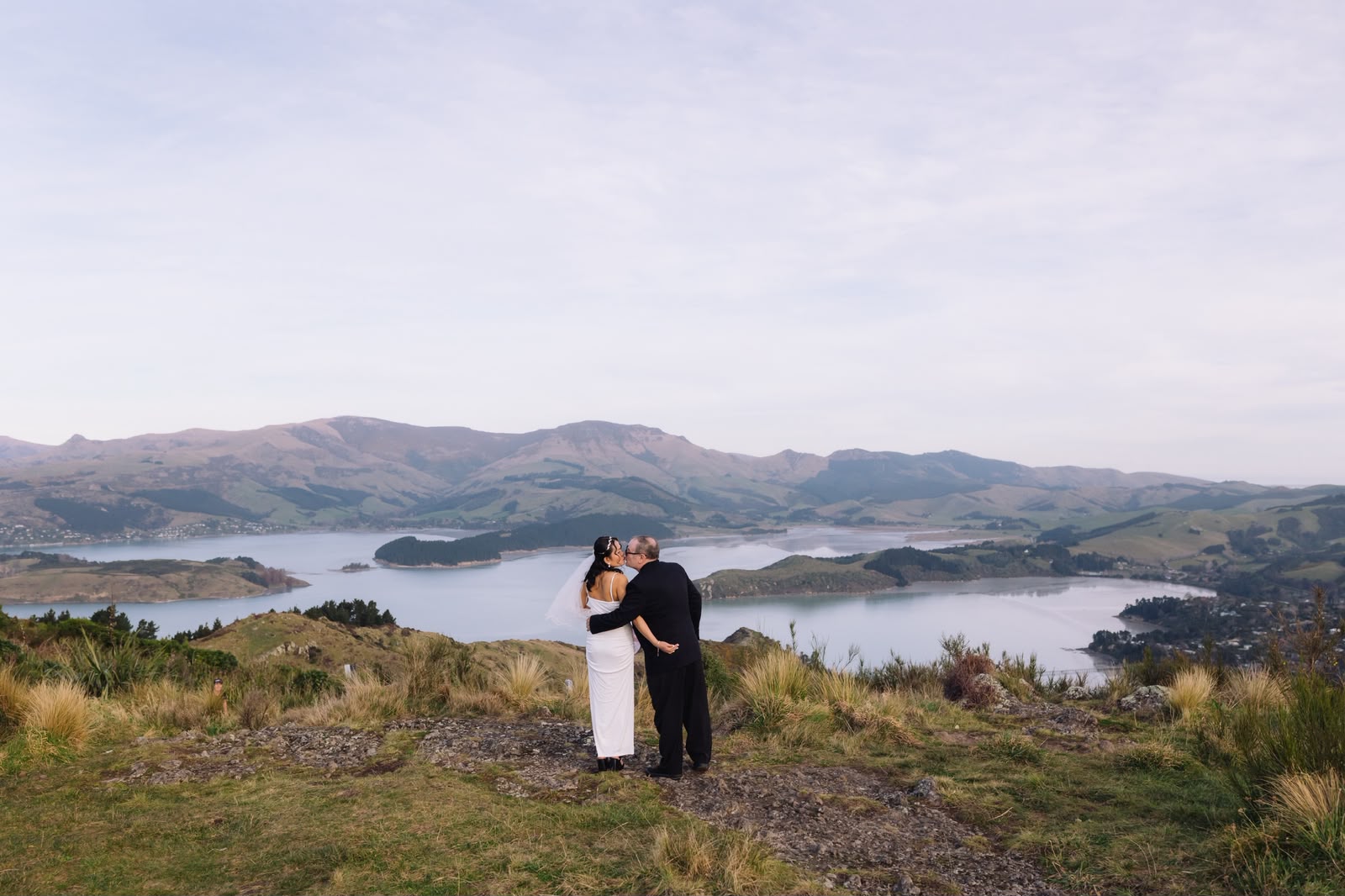 Couple embracing at a mountaintop wedding with a stunning harbour view