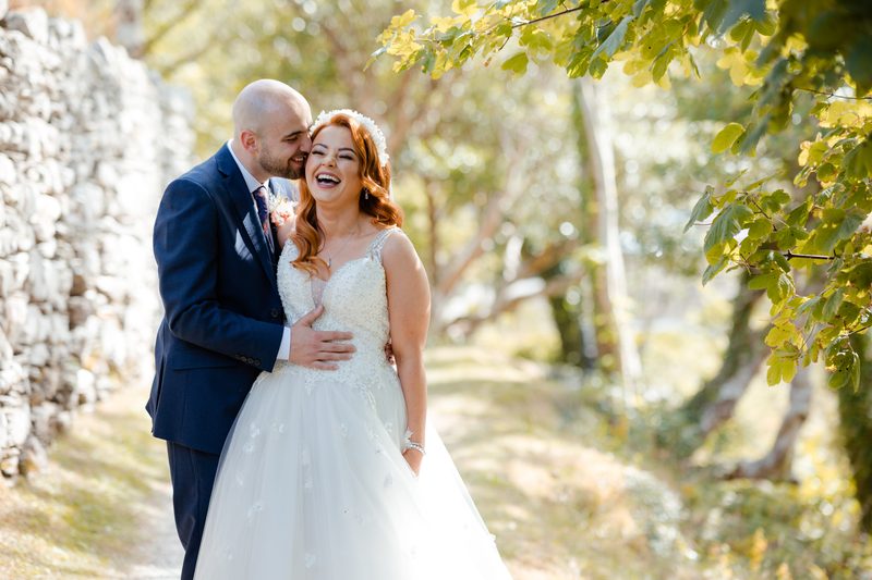 Bride smiling and leaning against groom